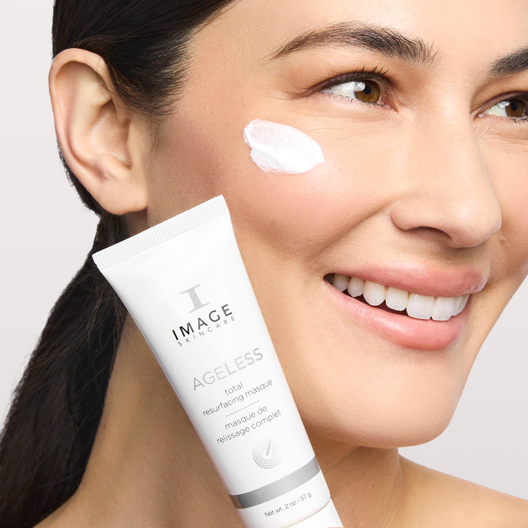 model with product on cheek and holding product tube