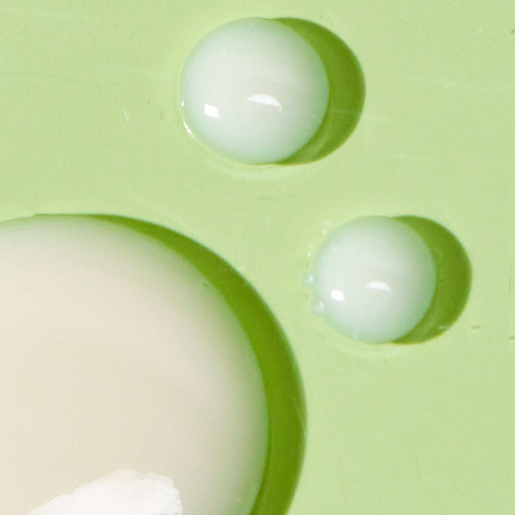 close up texture shot of serum on green background