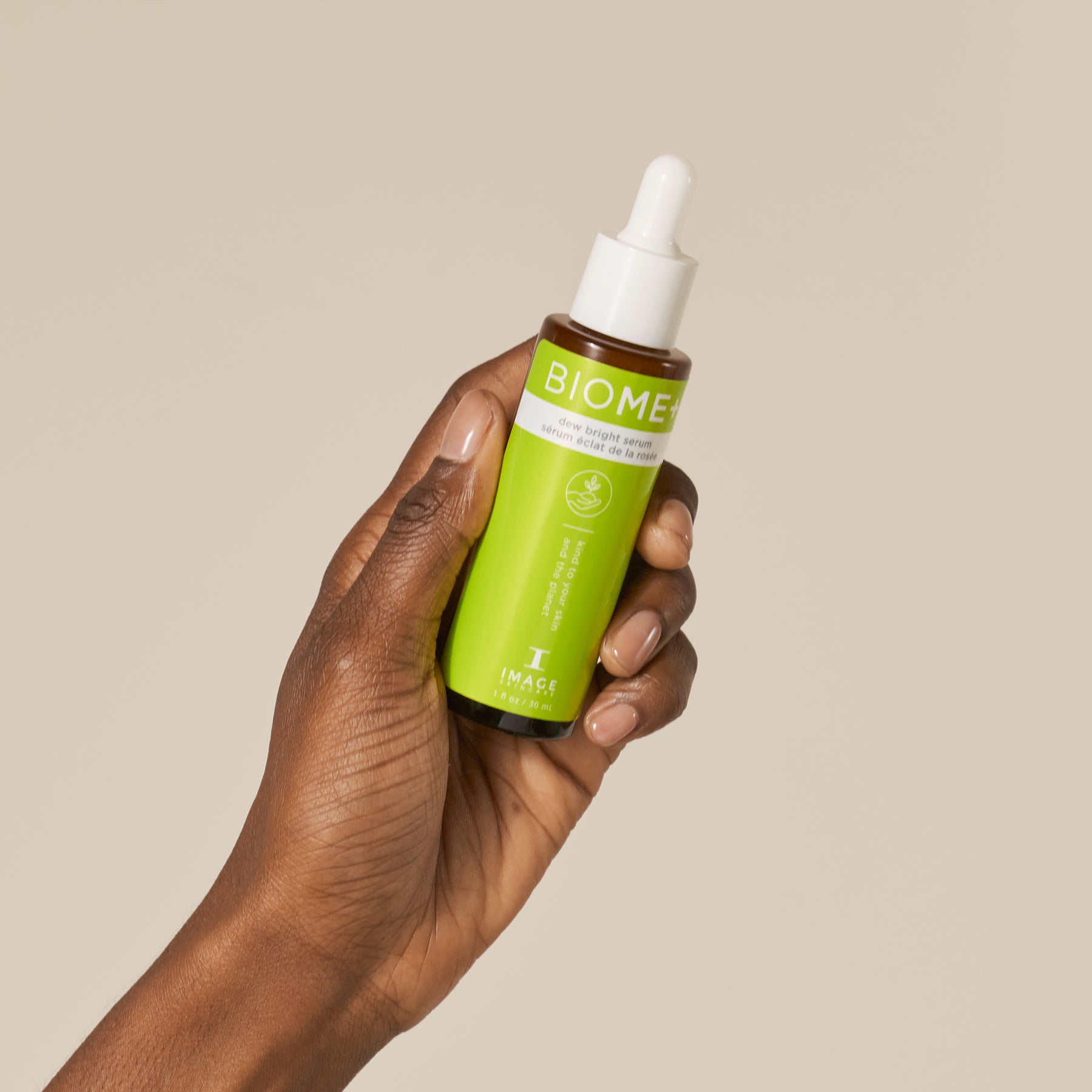 model hand holding BIOME+ dew bright serum bottle