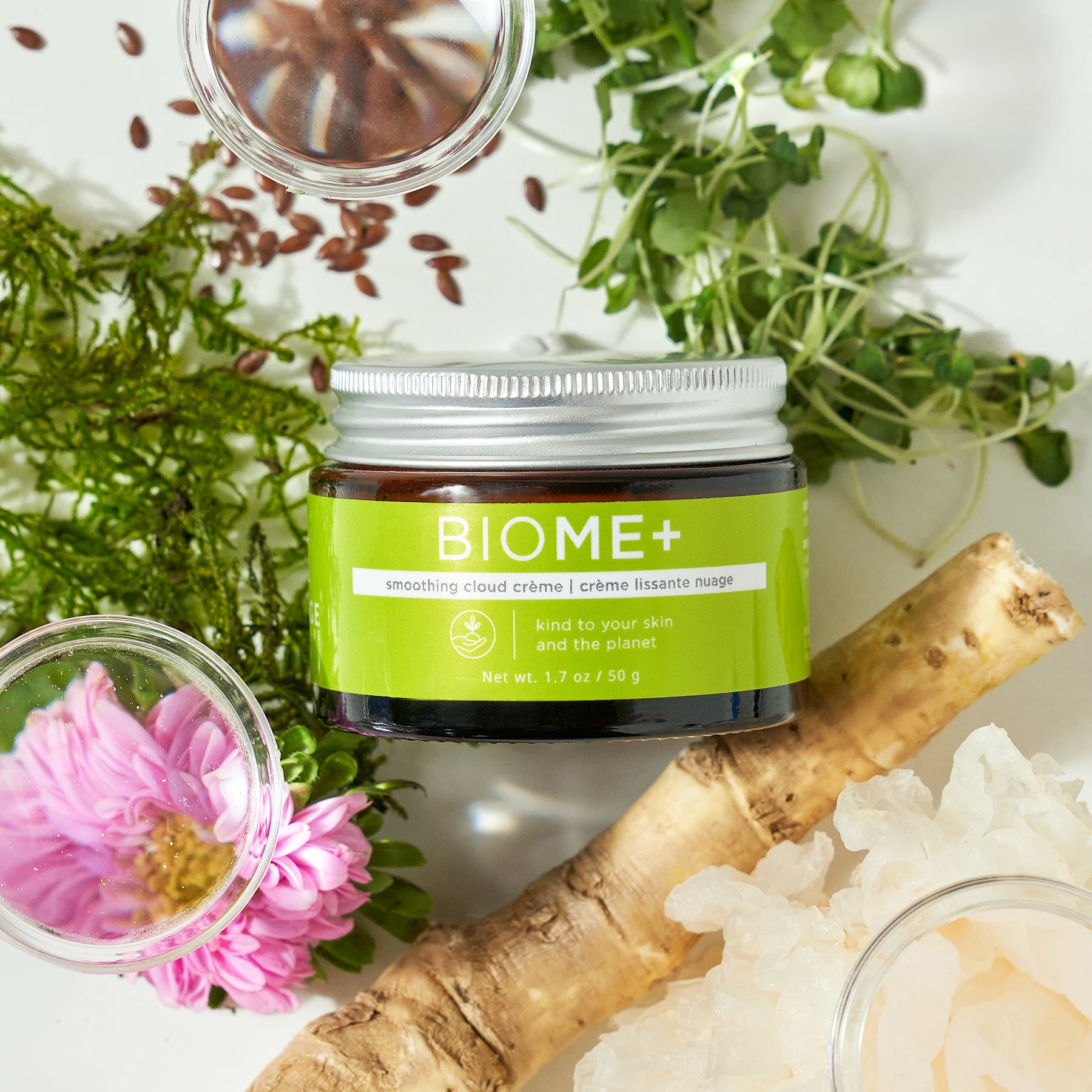 Biome+ smoothing cloud creme container laid in between petri dishes with ingredients and plant leaves