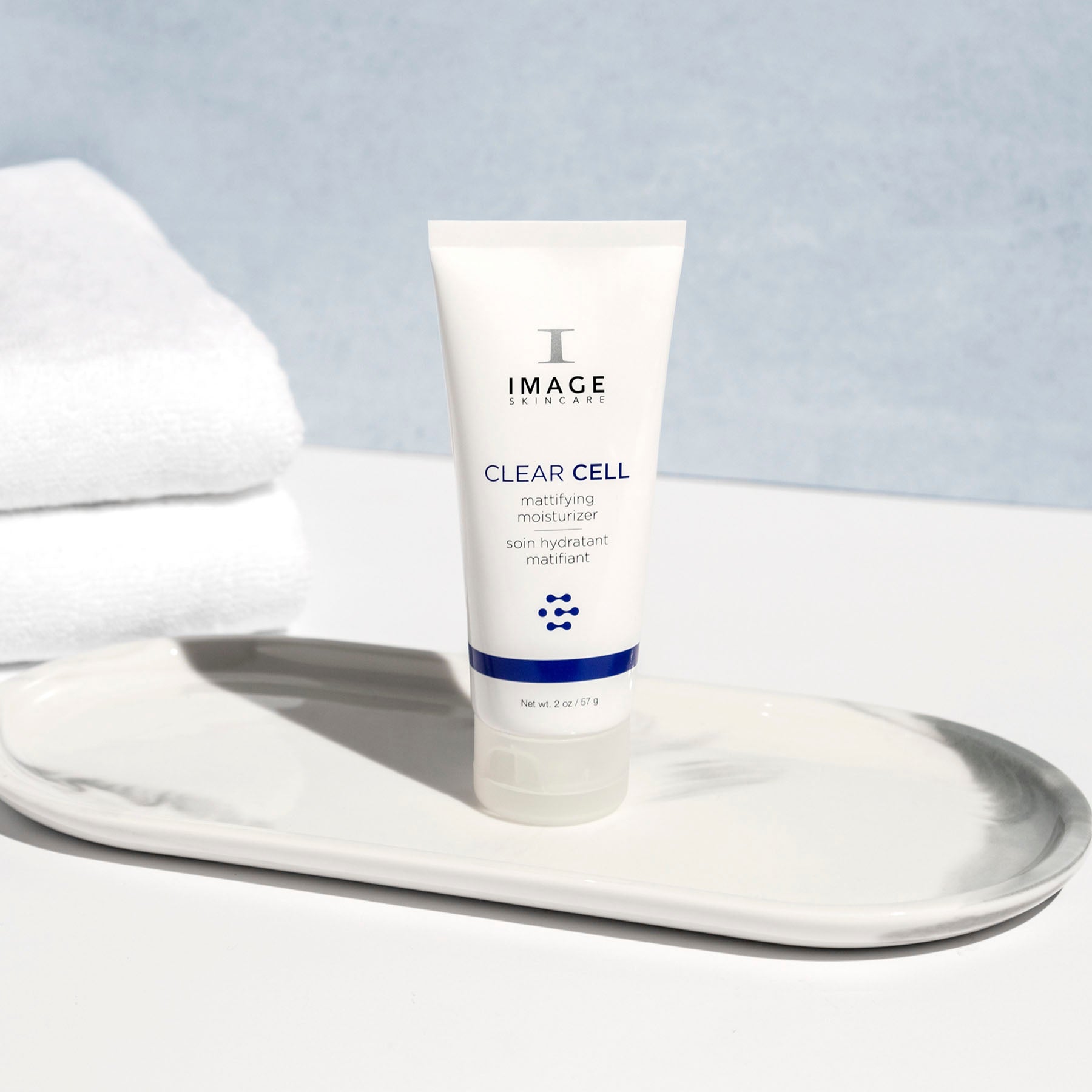 clear cell mattifying moisturizer bottle on bathroom counter