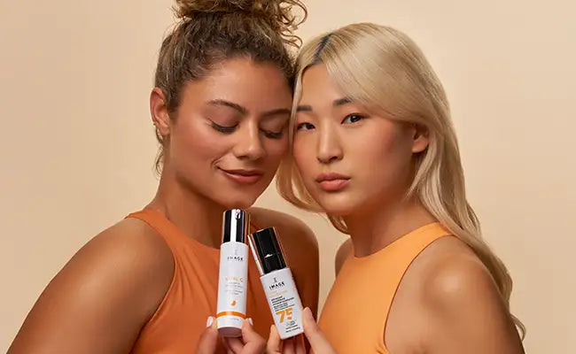 Two women holding IMAGE products for refer a friend.